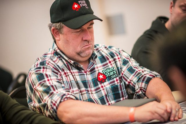 Chris Moneymaker playing poker wearing a flannel shirt and a black cap