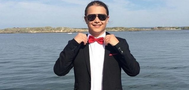 Niklas Astedt with a tuxedo and sunglasses in front of the sea